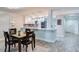 A dining area leading into the kitchen, featuring a modern table and a view of the entryway at 18400 Gulf Blvd # 1211, Indian Shores, FL 33785