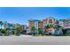 Exterior view of a multi-story beachfront condo with balconies and tropical landscaping at 18400 Gulf Blvd # 1211, Indian Shores, FL 33785