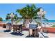 Community grilling area with multiple grills and lush palm trees against ocean backdrop at 18400 Gulf Blvd # 1211, Indian Shores, FL 33785