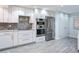 Modern kitchen with white cabinets, stainless steel appliances and wood-look tile at 18400 Gulf Blvd # 1211, Indian Shores, FL 33785