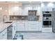 Modern kitchen with white cabinets, marble backsplash, and stainless steel appliances at 18400 Gulf Blvd # 1211, Indian Shores, FL 33785