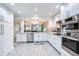 Open kitchen with white cabinets, granite counters, stainless appliances, and tile floors at 18400 Gulf Blvd # 1211, Indian Shores, FL 33785