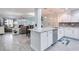 Open concept kitchen with white cabinets, stone countertops, and stainless steel appliances at 18400 Gulf Blvd # 1211, Indian Shores, FL 33785