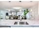 Open-concept living room featuring modern decor, a stone fireplace, and a view of the kitchen and dining area at 18400 Gulf Blvd # 1211, Indian Shores, FL 33785