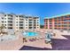 Inviting pool area with lounge chairs, tables, and a hot tub, ideal for relaxation and socializing at 18400 Gulf Blvd # 1211, Indian Shores, FL 33785