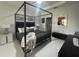 Bright bedroom featuring a canopy bed, modern furniture, and minimalist artwork at 19113 Doves Landing Dr, Tampa, FL 33647
