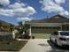 Charming single-Gathering home featuring a spacious two-car garage, well maintained landscaping, and a paved driveway at 19113 Doves Landing Dr, Tampa, FL 33647