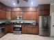 Modern kitchen with stainless steel appliances and warm wood cabinets at 19113 Doves Landing Dr, Tampa, FL 33647