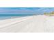 Scenic beach with white sand and blue ocean water, as people walk along the shoreline at 19823 Gulf Blvd # 42, Indian Shores, FL 33785
