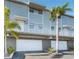 Modern condo with two stories, a garage, and landscaping with palm trees create a coastal charm at 19823 Gulf Blvd # 42, Indian Shores, FL 33785