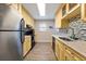 Galley kitchen with stainless steel appliances, tile backsplash, and light-colored cabinets at 19823 Gulf Blvd # 42, Indian Shores, FL 33785