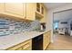 Bright kitchen with quartz countertop, colorful backsplash, and view to the living room at 19823 Gulf Blvd # 42, Indian Shores, FL 33785