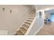 Staircase with wooden steps, white risers, and access to dining area at 19823 Gulf Blvd # 42, Indian Shores, FL 33785