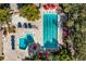 Aerial view of swimming pools with lap lanes, a splash pad area, lounge chairs, umbrellas, and landscaping at 20 Iris Pl, Oldsmar, FL 34677