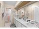 Bright bathroom featuring double sinks, a large mirror, and a shower with glass doors at 20 Iris Pl, Oldsmar, FL 34677