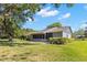 Exterior side view of a well-maintained home with screened porch and manicured landscaping at 20 Iris Pl, Oldsmar, FL 34677
