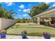 The large putting green features multiple holes, blue planters, covered seating area, and perimeter landscaping for an inviting outdoor space at 20 Iris Pl, Oldsmar, FL 34677