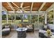 Inviting screened porch features wood ceiling, ceiling fan, and comfortable seating with a golf course view at 20 Iris Pl, Oldsmar, FL 34677