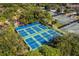 Aerial shot of multiple tennis and pickleball courts, surrounded by lush landscaping, offering ample recreation space at 20 Iris Pl, Oldsmar, FL 34677