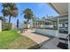 A beautiful backyard pool area with a screened in porch, lush green grass, and tropical landscaping at 2310 Sunrise Se Dr, St Petersburg, FL 33705