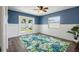Bright bedroom features stylish blue accent wall, wood floors, ceiling fan, and a walkout to the backyard at 2310 Sunrise Se Dr, St Petersburg, FL 33705