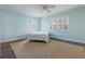 Light filled bedroom with wood floors, ceiling fan, and two windows with wood shutters at 2310 Sunrise Se Dr, St Petersburg, FL 33705