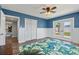 Bright bedroom features stylish blue accent wall, wood floors, ceiling fan, and a walkout to the backyard at 2310 Sunrise Se Dr, St Petersburg, FL 33705