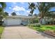 Well-maintained light-blue home with a lush front yard, mature landscaping, and a driveway at 2310 Sunrise Se Dr, St Petersburg, FL 33705