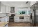 Modern kitchen boasts white cabinets, stainless steel appliances, and wood-look flooring at 2310 Sunrise Se Dr, St Petersburg, FL 33705