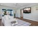 Bright living room featuring hardwood floors, fresh paint, and a large-screen television at 2310 Sunrise Se Dr, St Petersburg, FL 33705