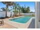 Private swimming pool surrounded by mature tropical trees and white fence at 2310 Sunrise Se Dr, St Petersburg, FL 33705
