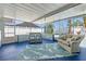 Enclosed sunroom with tile floor, seating area, and view of the backyard pool at 2310 Sunrise Se Dr, St Petersburg, FL 33705
