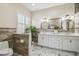 Bright bathroom featuring dual sinks, white cabinets, and a walk in shower at 2632 Tarragona Way, Wesley Chapel, FL 33543