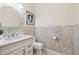 Elegant bathroom featuring wainscoting, a decorative mirror, and a classic vanity at 2632 Tarragona Way, Wesley Chapel, FL 33543