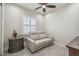 Cozy bonus room with plush seating, a ceiling fan, and shuttered windows providing natural light at 2632 Tarragona Way, Wesley Chapel, FL 33543