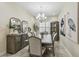 Dining room featuring a chandelier, elegant furniture, and a stylish display cabinet at 2632 Tarragona Way, Wesley Chapel, FL 33543