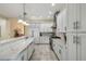 Modern kitchen featuring white cabinets, marble countertops, and stainless steel appliances at 2632 Tarragona Way, Wesley Chapel, FL 33543