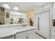 Kitchen island with white cabinets, marble countertops, a sink, and view into dining area at 2632 Tarragona Way, Wesley Chapel, FL 33543