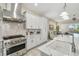 Bright kitchen features white cabinets, marble countertops, and stainless steel appliances at 2632 Tarragona Way, Wesley Chapel, FL 33543