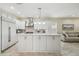 Bright kitchen features white cabinets, a marble backsplash, stainless steel appliances, and an island with pendant lighting at 2632 Tarragona Way, Wesley Chapel, FL 33543