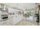 Open concept kitchen and living area featuring a large island, modern appliances, and sliding glass doors at 2632 Tarragona Way, Wesley Chapel, FL 33543