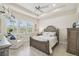 Comfortable main bedroom with tray ceiling, wood floors, and plantation shutters on the windows at 2632 Tarragona Way, Wesley Chapel, FL 33543