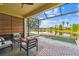 Covered patio featuring comfortable seating and stunning lake views and access to the pool at 2632 Tarragona Way, Wesley Chapel, FL 33543