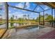 Relaxing screened-in lanai with a water view, spa, and room to lounge at 2632 Tarragona Way, Wesley Chapel, FL 33543