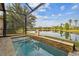 Gorgeous spa pool overlooking the lake with beautiful landscaping and screened enclosure at 2632 Tarragona Way, Wesley Chapel, FL 33543