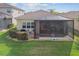 Rear exterior showing backyard with lawn, spa, and covered lanai at 2632 Tarragona Way, Wesley Chapel, FL 33543