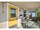 Inviting front porch with a bright yellow door, seating, and decorative details at 2818 N 19Th St, Tampa, FL 33605