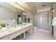Bathroom with double sinks, a glass-enclosed shower, and a large mirror at 2932 Sweetgum S Way, Clearwater, FL 33761
