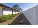 Exterior view of a white home with a white fence and maintained hedges against the house at 2932 Sweetgum S Way, Clearwater, FL 33761