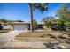 Charming single-story home with a well-manicured lawn, mature trees, brick driveway, and a two-car garage at 2932 Sweetgum S Way, Clearwater, FL 33761